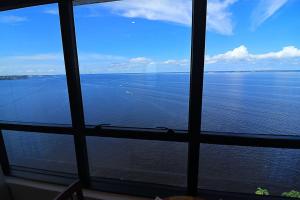 a view of the ocean from a large window at Tropical Executive 1307 With View in Manaus