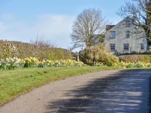 a road in front of a house with flowers at Yonderton Mcgill Cottage - Uk11182 in Hollybush