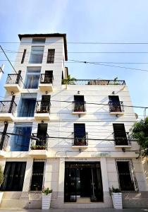 a white building with balconies on the side of it at Hotel Carolina Del Mar in Santa Marta