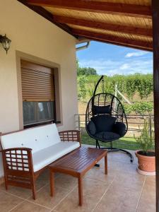 a patio with a bench and a wicker chair at Apartmani Milosavljević in Kuršumlija