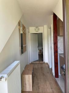 a hallway with a table and a clock on the wall at Apartmani Milosavljević in Kuršumlija