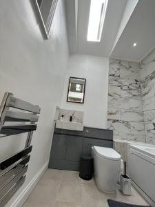 a bathroom with a toilet and a sink and a tub at Bella Ripley in Ripley