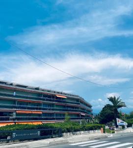 un gran edificio con una palmera delante en Studio bord de mer avec parking privé, en Cannes