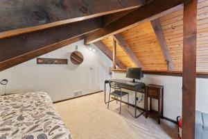 Schlafzimmer mit einem Bett und einem Schreibtisch mit einem Laptop in der Unterkunft The Bear's Den Chalet in Stateline