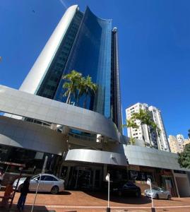 un grande edificio con macchine parcheggiate di fronte di Fabulosa Suite 903 em Flat Alto Padrão a Londrina