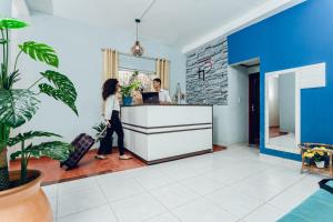 Un uomo e una donna in piedi al bancone in una cucina di Hostel Filhos da Promessa a Tucuruí