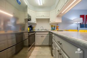 a kitchen with white cabinets and stainless steel appliances at Hello Sunshine Steps To the Beach in Destin