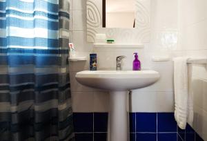 a bathroom with a sink with a purple bottle on it at Villa Oleandro in Scopello