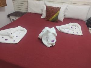 a bed with white towels on top of it at Apto Cavalinho Branco in Águas de Lindóia +8 photos