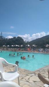 a group of people swimming in a swimming pool at Apto Cavalinho Branco in Águas de Lindóia