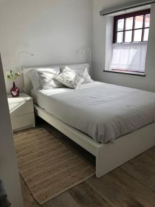 een wit bed in een slaapkamer met een raam bij SUNSEA HOUSE in Altares