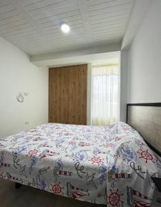 een slaapkamer met een bed met een bloemenbed bij Encanto y confort en el corazón del Quindío in Armenia