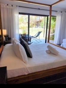uma cama grande num quarto com uma janela grande em La Bonita Suites Punta Colorada em Punta Colorada