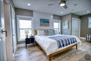 um quarto com uma cama e duas janelas em Tropical Oasis, Heated Pool, Hot Tub, Near Siesta Key em Sarasota