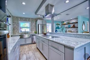 uma grande cozinha com bancadas brancas e paredes azuis em Tropical Oasis, Heated Pool, Hot Tub, Near Siesta Key em Sarasota