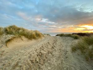 a dirt road through the sand dunes at the beach at 1min walk to Beach- Happy Waves- Family Home in Camber