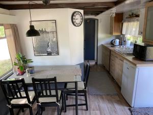 a kitchen with a table and chairs and a clock on the wall at Ostoja in Lucień