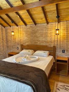 a bedroom with a large bed in a room at Chales Bela Serra in Monte Verde