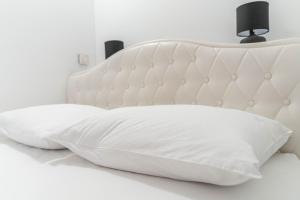 Una cama blanca con dos almohadas. en Apartman Lara, en Šestanovac