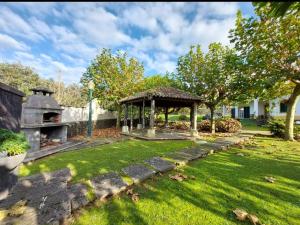 a garden with a gazebo and a grill at Quinta do Sossego-Giestas in Ribeira Grande
