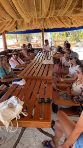 un grupo de personas sentadas en bancos bajo un paraguas en Dhiffushi Island Villa, en Dhiffushi