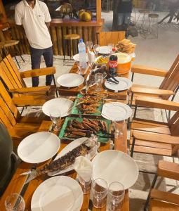a wooden table with plates of food on it at Dhiffushi Island Villa in Dhiffushi