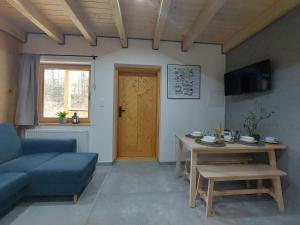 a living room with a blue couch and a table at Domki Zew Natury in Lesko