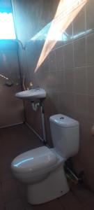 een badkamer met een wit toilet en een wastafel bij Raja Grya in Tirtagangga