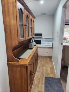 a kitchen with wooden cabinets and a stove at Spencer Lane Cottage & Granny Flat in Stanthorpe