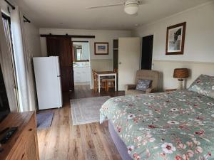 a bedroom with a bed and a refrigerator and a table at Spencer Lane Cottage & Granny Flat in Stanthorpe