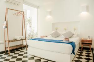 a white bedroom with a bed and a mirror at La Puerta Azul in Santa Marta +23 photos