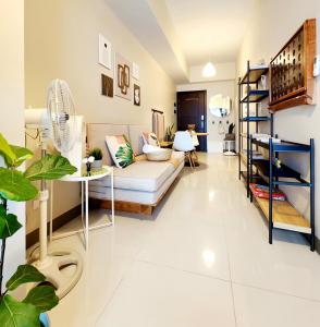 een woonkamer met een bank en een ventilator bij Cozy Minimalist Unit at BGC Mall Free Parking in Manilla