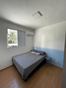 a small bedroom with a bed and a window at SPAZIO LA VITTA LONDRINA in Londrina