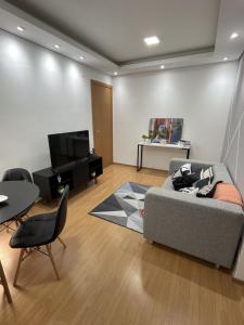 uma sala de estar com um sofá e uma mesa em SPAZIO LA VITTA LONDRINA em Londrina