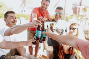a group of people holding bottles of beer at Gijon Surf Hostel in Gijón