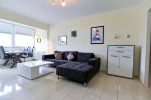 a living room with a couch and a table at Strandhochhaus SB10 in Cuxhaven