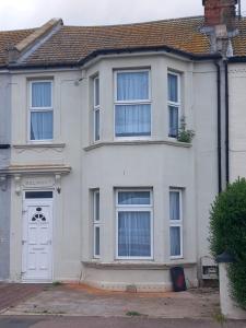 a white house with a white door and windows at Beach palace in Clacton-on-Sea