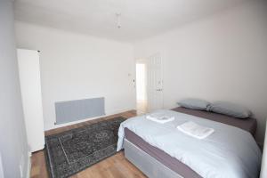a white bedroom with a bed and a television at Beach palace in Clacton-on-Sea