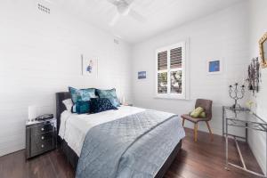 um quarto branco com uma cama e uma cadeira em COOK3R - Character on Cook Street em Sydney