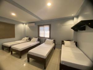een kamer met 3 bedden en een schoolbord bij Lakayo Hillside Apartelle in san juan la union