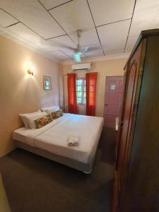 een slaapkamer met een groot wit bed en een roze deur bij Seri Pengantin Resort in Kampung Janda Baik