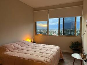 ein Schlafzimmer mit einem großen Bett und einem großen Fenster in der Unterkunft Depto a estrenar increíble vista 180º Cocha in Cochabamba
