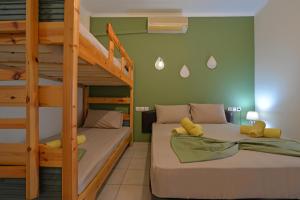 a bedroom with two bunk beds and a ladder at Studios Λύδια in Paralía Skotínis