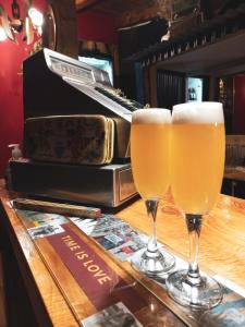 dos vasos de cerveza sentados en un bar con un piano en Hostel Luan Posada de Montaña en Trevelín