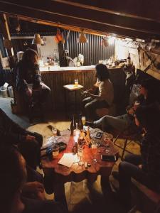 un grupo de personas sentadas alrededor de una mesa en una habitación en Hostel Luan Posada de Montaña en Trevelín