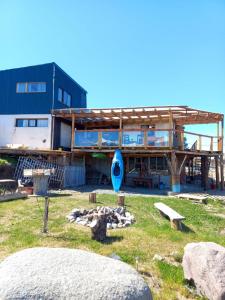 un edificio con una casa con un kayak azul en un patio en Hostel Luan Posada de Montaña en Trevelin