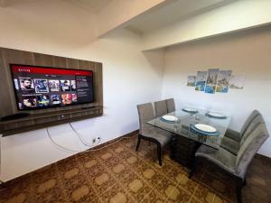 um quarto com uma mesa e cadeiras e uma televisão de ecrã plano em Ao Lado do Aeroporto com vaga coberta em Guarulhos