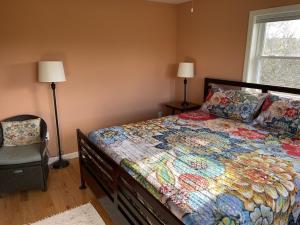 a bedroom with a bed and a chair and a window at Spindrift in Eastport