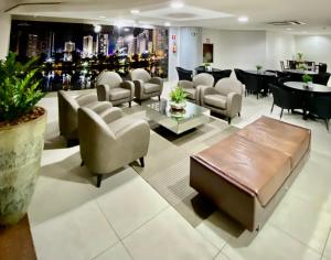 a waiting room with chairs and a couch and tables at Special Flat Alto Padrão em Hotel na melhor Localização in Londrina
