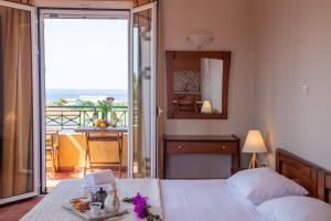 a bedroom with a bed and a view of the ocean at Vitoratos Studios in Lixouri